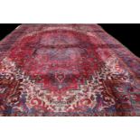 A large rectangular woollen carpet, colourfully worked in the typical Middle Eastern manner with