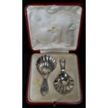 A case of Edwardian silver caddy spoons, of George III design, shell bowls, one bright-cut engraved,