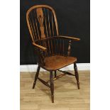 A 19th century elm Windsor elbow chair, tall hooped back with shaped and pierced splat, U-shaped arm