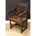 A '17th century' oak Wainscote armchair, shaped cresting rail carved with strapwork and flanked by