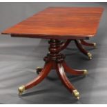 A Regency mahogany twin pillar dining table, rounded rectangular top with reeded edge, additional