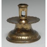 A 16th century brass capstan candlestick, pierced cylindrical sconce, broad shaped circular drip pan