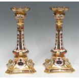 A pair of Royal Crown Derby 1128 pattern Castleton candlestick, outswept square base with dolphins