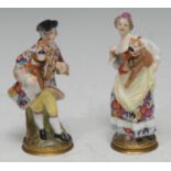 A pair of Meissen type figural scent/perfume bottles, of a lady and gallant each holding a pug,