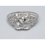 An Art Deco style diamond ring, central round old brilliant cut diamond approx 1.15ct, collar set