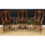 A suite of three French walnut elbow chairs, in the 18th century taste, shaped backs with carved