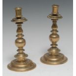 A pair of late 17th century bell metal candlesticks, cylindrical sconces, galleried drip pans,