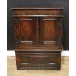 An '18th century' oak cabinet on stand, rectangular top above a deep frieze and a pair of doors,