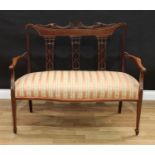 An Edwardian inlaid mahogany salon sofa, carved and pierced three panel back, tapering supports,