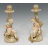 A pair of Royal Worcester figural candlesticks, modelled by James Hadley, as a boy and girl