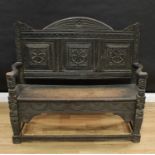 A 19th century oak hall bench, arched three-panel back profusely carved in the 17th century taste,