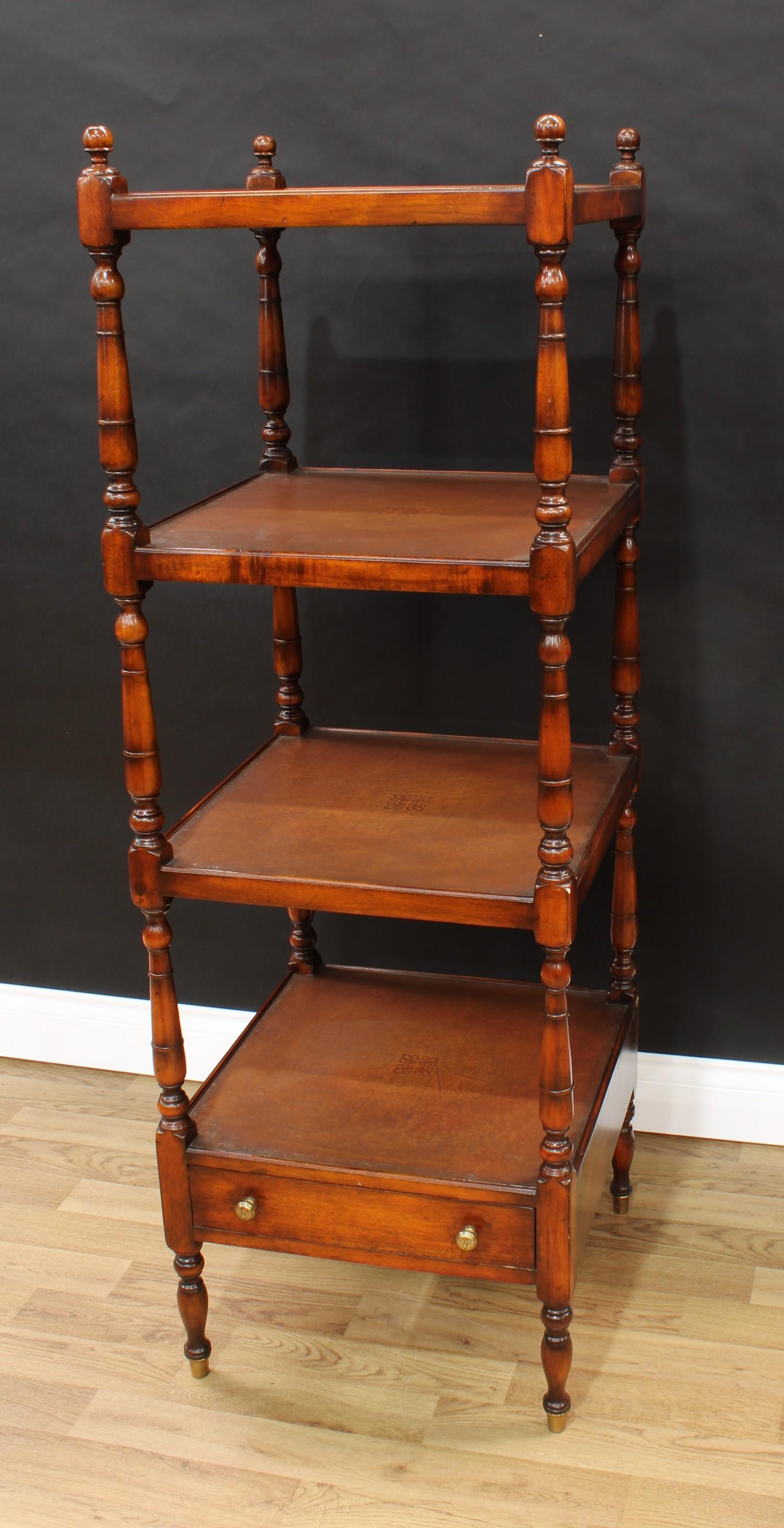 A Regency style mahogany whatnot, each square plateau lined with tan leather, turned finials and