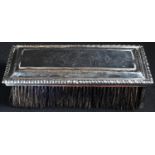 A George II silver clothes brush, engraved with a leafy scroll cartouche, gadrooned border, 18cm