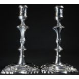 A pair of 18th century Irish cast silver candlesticks, reel shaped sconces, knopped pillars,