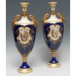 A pair of Coalport pedestal ovoid urns, with oval landscape cartouches, within lemon and gilt