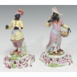 A pair of Continental figures, of Blackamoors, in traditional dress, pierced bases, 17.5cm high, c.