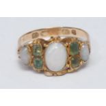 A 19th century opal and emerald panel ring, three graduated opal cabochons, with vibrant red