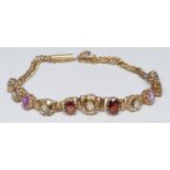 A fancy multi-gem articulated bracelet, central eleven stone graduated crest inset with assorted