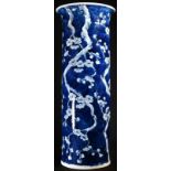 A Chinese sleeve vase, painted in tones of underglaze blue with blossoming prunus on a ground of