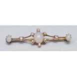 An opal and diamond bar brooch, open cast bar set with three oval cabochon opals and eight round