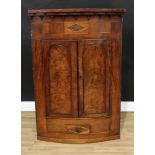 A George IV mahogany bow-fronted wall hanging corner cupboard, stepped cornice applied with split-