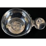 A French silver wine taster, the lug handle engraved with a reveling epicure, the bowl inset with