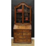 An 18th century Dutch walnut and marquetry bureau bookcase, shaped cresting above a pair of glazed