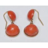A pair of coral drop earrings, each with two section circular cabochon droplet, yellow metal