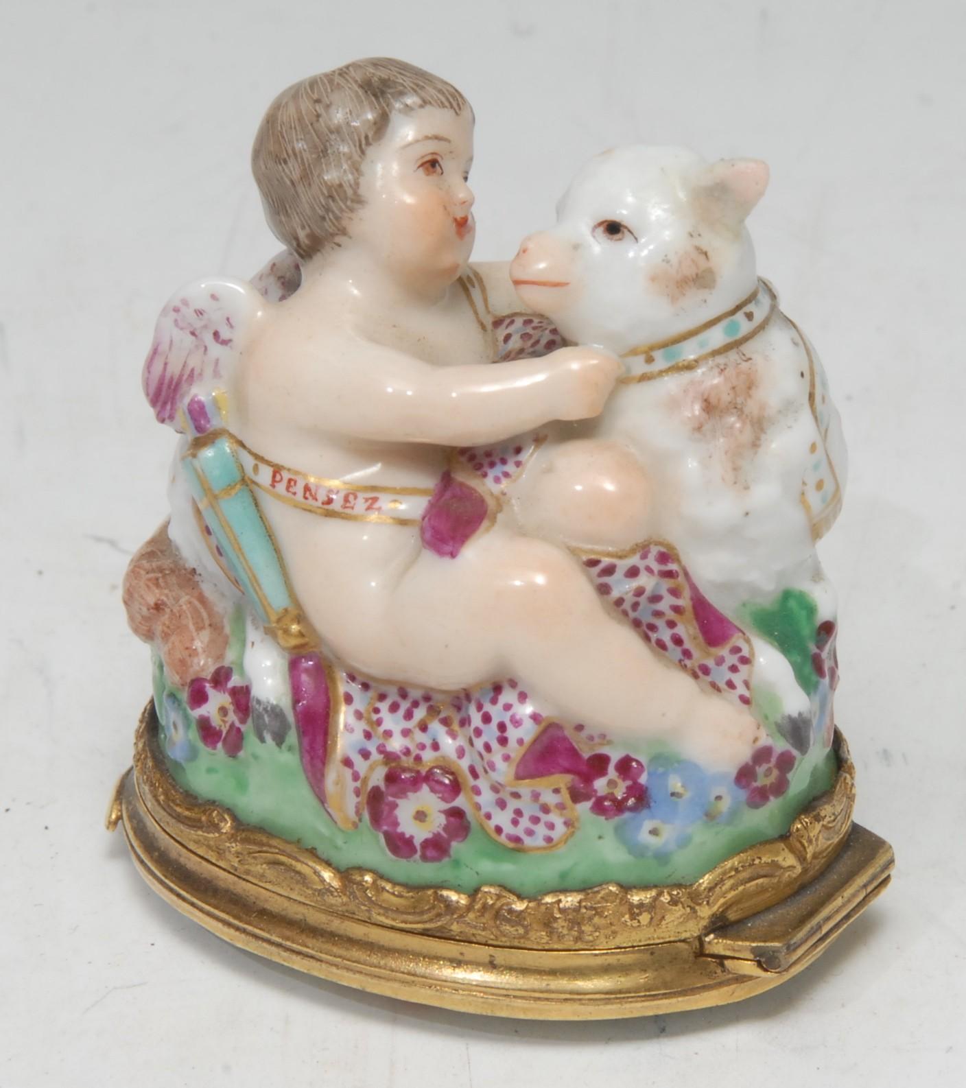 A French gilt metal mounted bonboniere, modelled with cherub and lamb, the cover and interior with