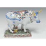 A Dutch Delft pottery figure group, of a cow and milkmaid, decorated in polychrome enamels ,