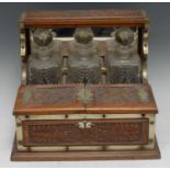 A Victorian E.P.N.S mounted oak three-bottle tantalus, the square decanters restrained within a