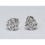 A pair of diamond floral cluster earrings, central round brilliant cut diamond surrounded by six