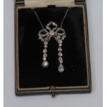 An Art Deco diamond and pearl pendant necklace, tied ribbon center bow supporting two droplets, pave