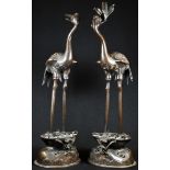 A pair of Chinese two-section dark patinated bronze cranes, standing with beaks open, shaped oval