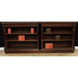 A pair of Victorian oak open library bookcases, each with moulded top above a deep frieze carved