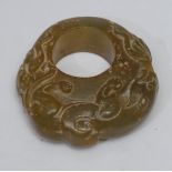 A carved jade ring, the single piece of polished jade, exterior carved as a stalking mythical