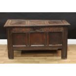 A Charles II oak three panel blanket chest, hinged top enclosing a till, the frieze carved with