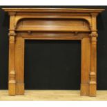 A late Victorian oak country house chimney piece, rectangular mantel above an arched niche,