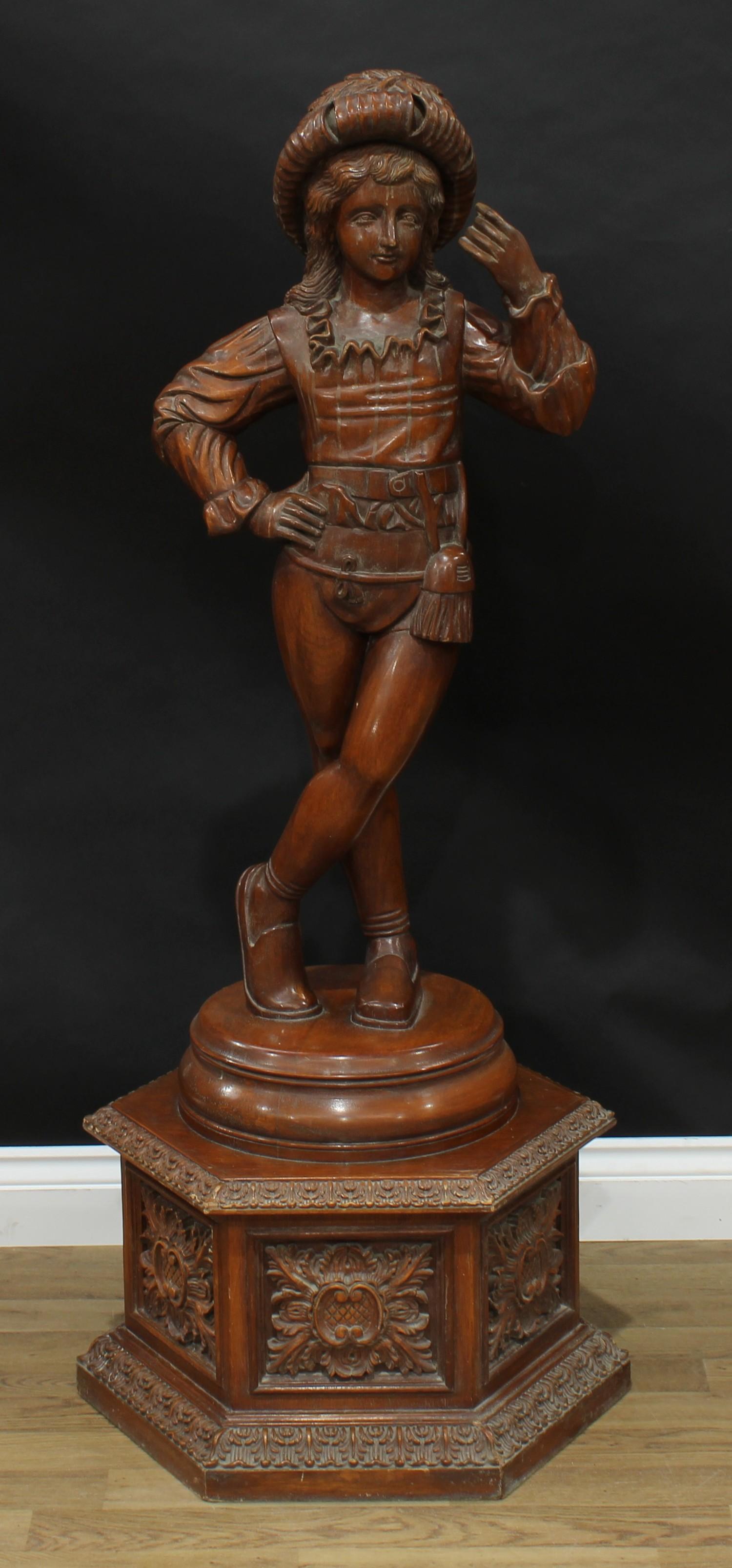 An Italian hardwood floor standing figure, carved in the blackamoor tradition, as a finely dressed