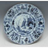 An 18th century Delft circular dish, painted after Chinese Kraak porcelain in tones of blue with