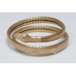 A gilt metal snake bangle, coiled articulated unmarked scale mesh body, 40.6g gross
