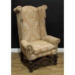 A Colonial hardwood wingback armchair, in the Spanish Baroque taste, stuffed over upholstery,