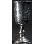 A Russian silver pedestal vodka cup, the bell shaped bowl engraved with houses and stiff leaves,