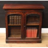 An early Victorian mahogany bookcase, of diminutive proportions, oversailing rectangular top above a