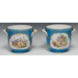 A pair of Sevres ice buckets, decorated courting couple within a gilt cartouche, on a blue celeste