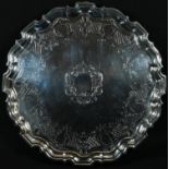 A George II silver shaped circular salver, the field flat-chased with a Roccoco band of leafy