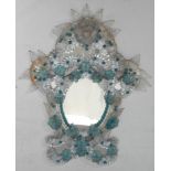 A Murano cartouche shaped mirror, applied with blue flowerheads and white leaves, 55cm high, 44cm