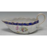 An 18th century Chelsea sauceboat, of rare shape painted with flowers under a Smith?s blue border,