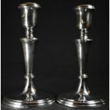 A pair of Elizabeth II silver candlesticks, urnular sconces, knopped tapered pillars, domed circular