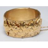 A Neoclassical gilt metal cuff bangle, wide body of trailing interlaced overlapping leaves,